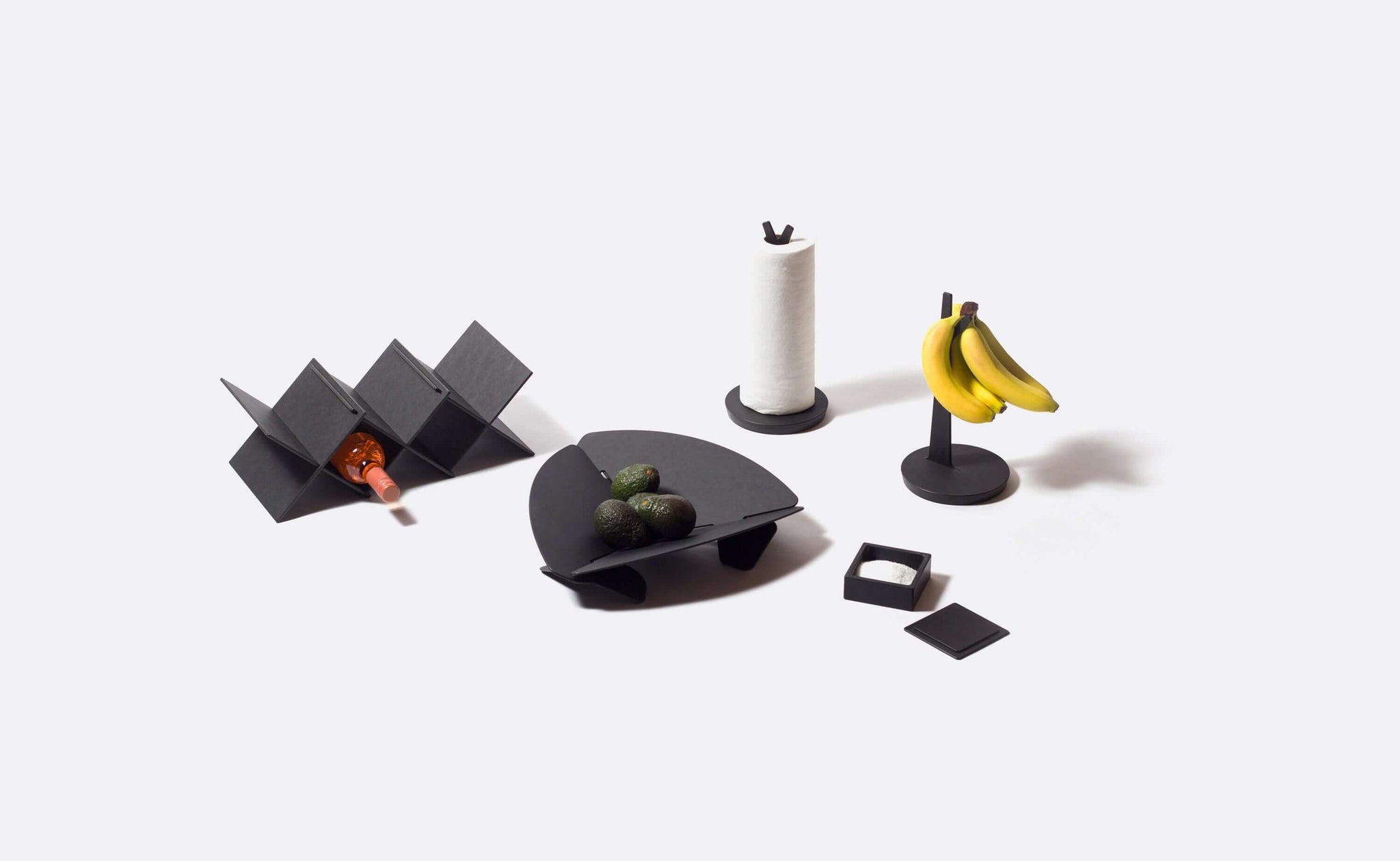 The Countertop series features collectively on a white background. Including Wine rack, Paper Towel Holder, Banana Holder, Salt Cellar, and Collapsible Handy Bowl in Slate Color. 